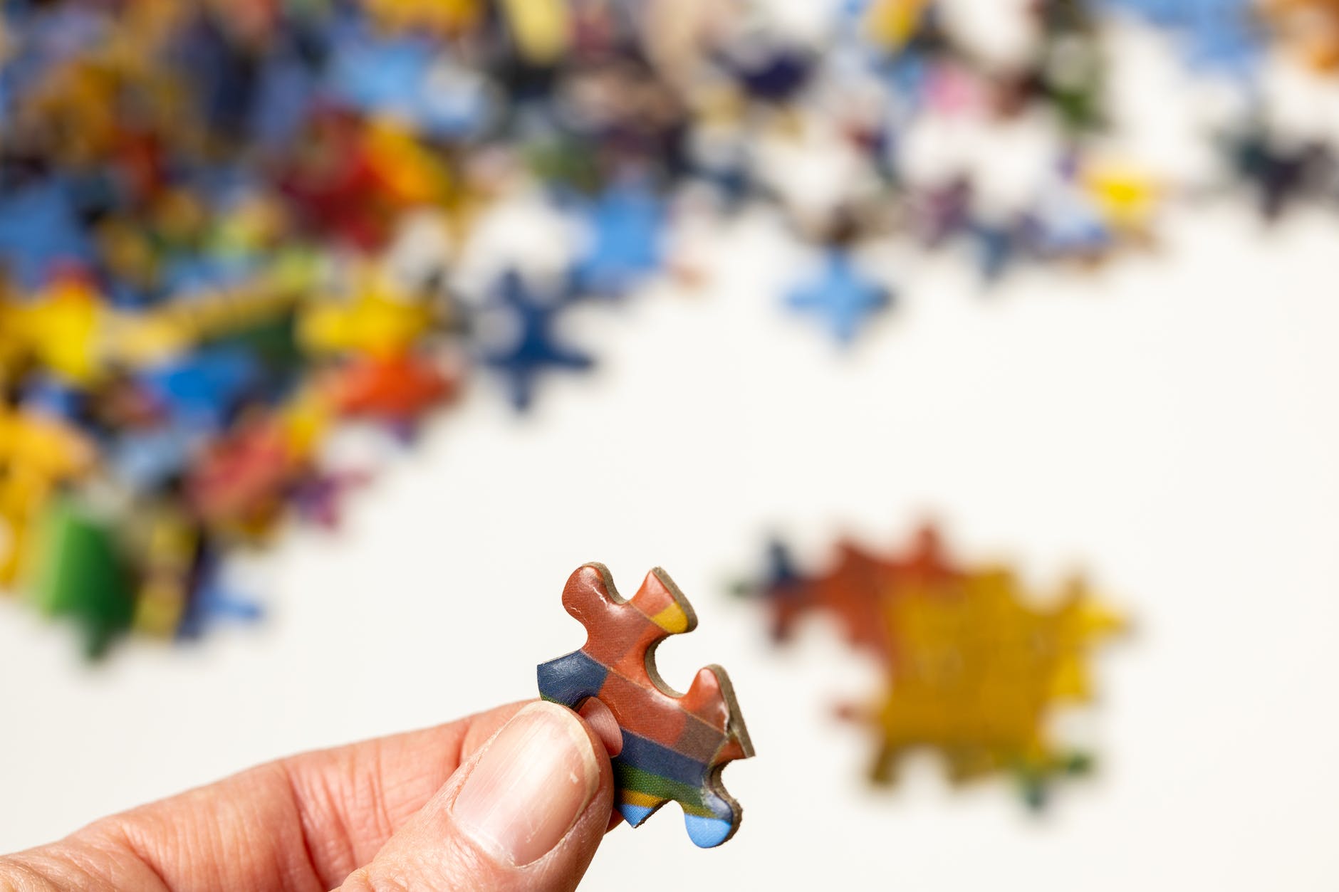 person holding jigsaw puzzle piece