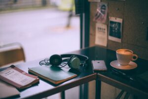 headphones near smartphone and cappuccino on cafe table